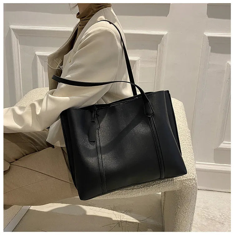 Large capacity soft leather tote bag in beige with synthetic leather lining and double shoulder straps.