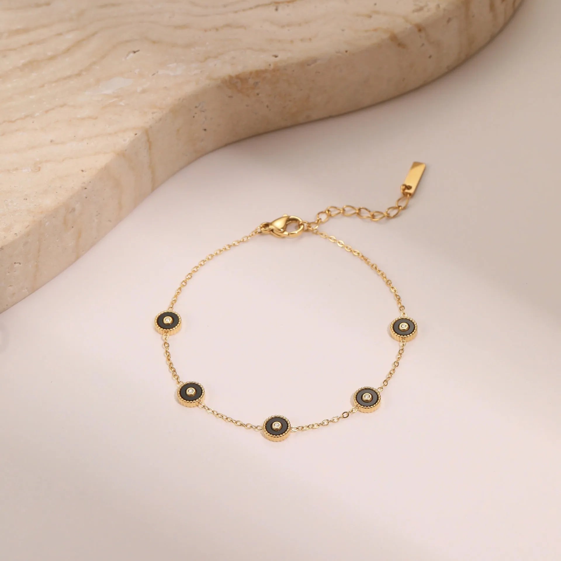 Stainless steel bracelet with 18K gold electroplating and geometric fritillary design, shown with matching necklace