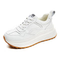 Beige women's cowhide leather low-top sports shoes with cross-strap and visible stitching on a round toe.