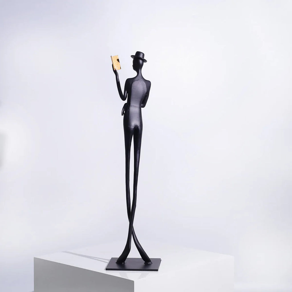 Black metal reading woman desktop sculpture made of cast aluminium measuring 51 cm tall