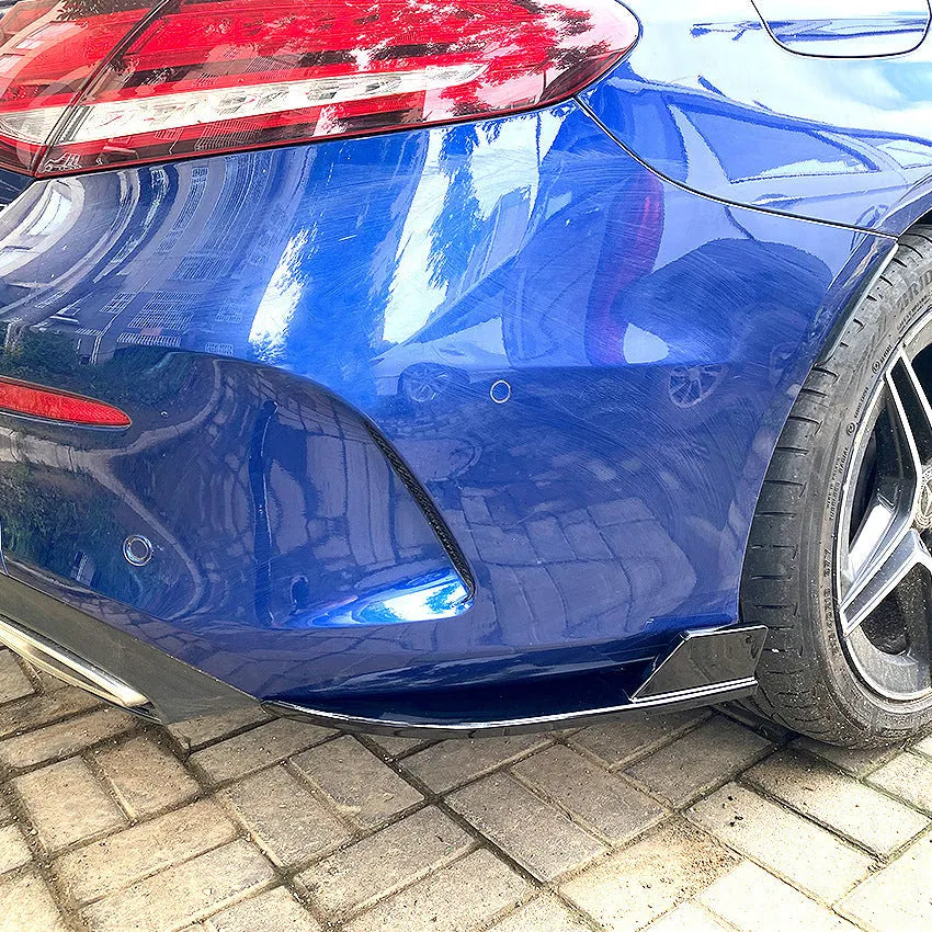 Pair of car rear bumper corner protectors in carbon fibre pattern on a vehicle rear corner