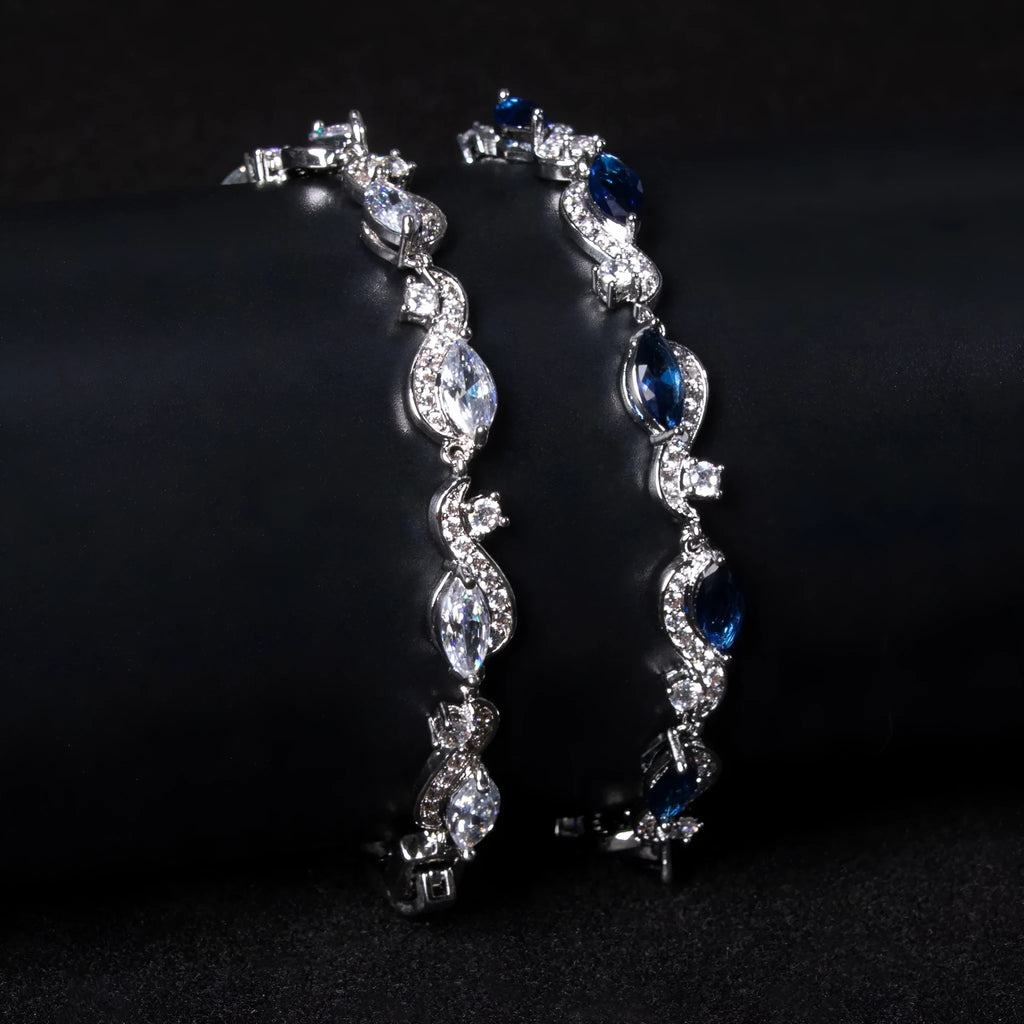 Women's copper geometric line bracelet with inlaid blue zircon stones on a white background