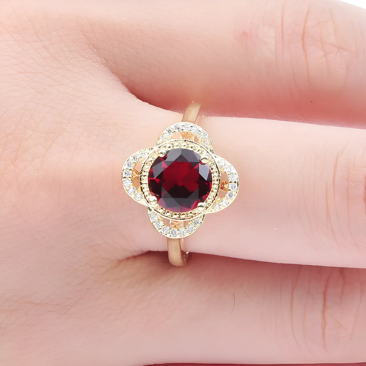 Copper fruit-shaped ring with inlaid zircon gemstones on a model's finger.
