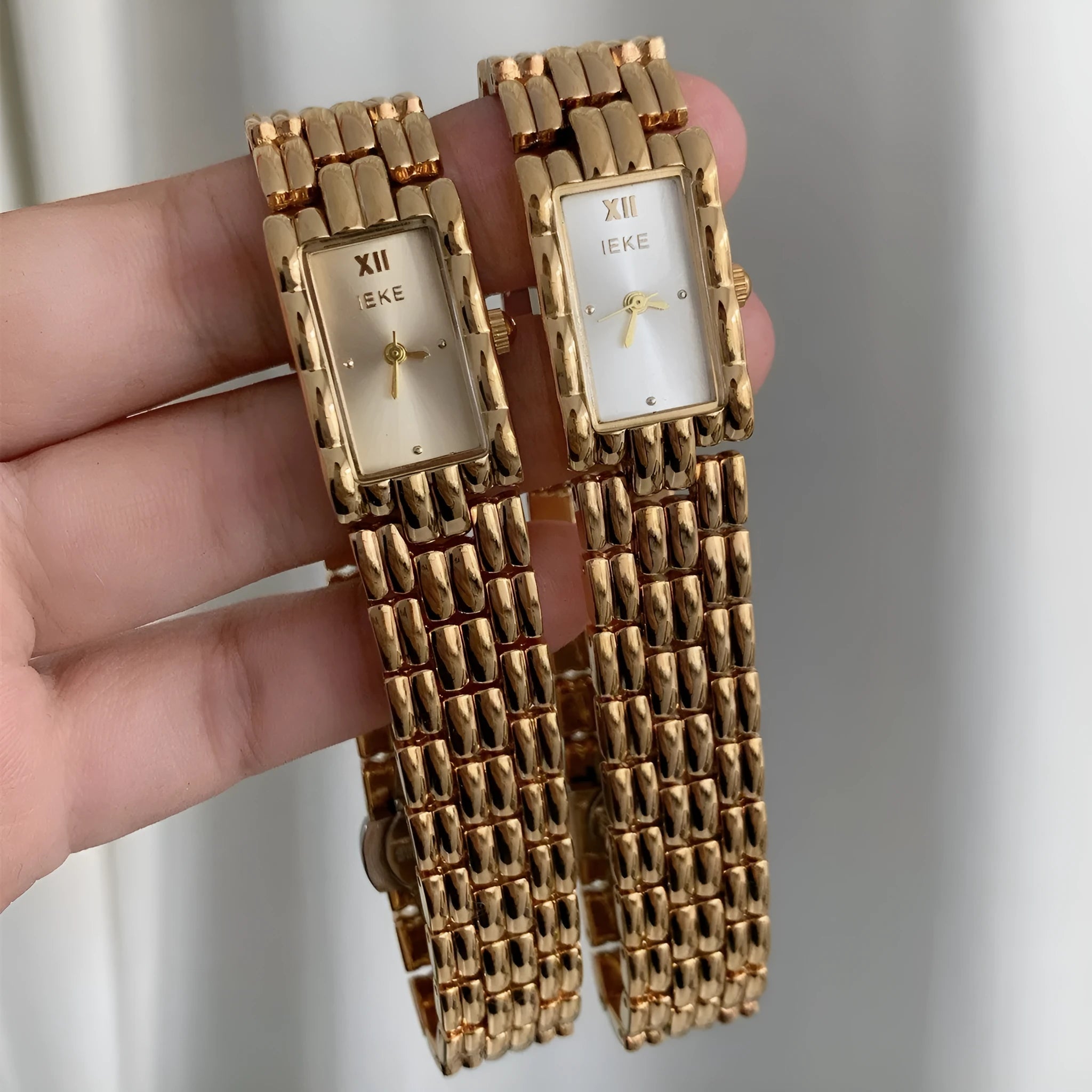 Women's antique-style bracelet watch with small white dial on a silver strap, showing butterfly buckle.