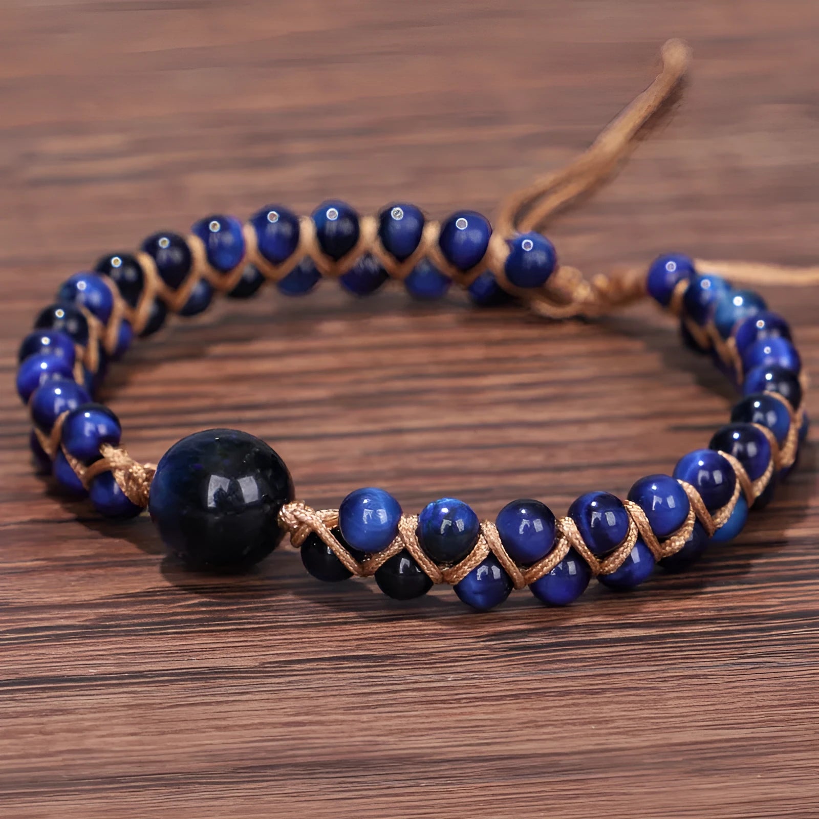 Close-up of a handmade woven pull bracelet with geometric pattern in blue Tigereye stone beads.