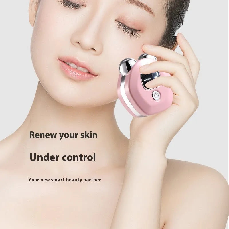 Portable white hot compress and micro current facial massage instrument with double rollers on a table.