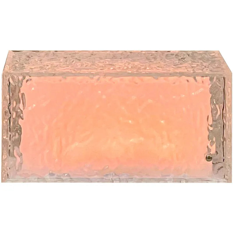 Geometric ice cube-shaped night lamp with coloured lighting on wooden surface