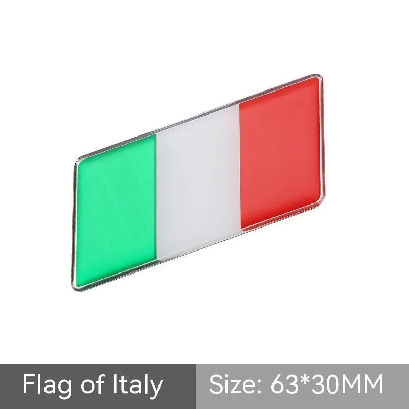 Aluminium national flag car sticker in a parallelogram shape measuring 6.3 by 3 centimetres.