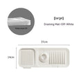Silicone faucet splash guard pad with sloped design and drain holes on a kitchen sink