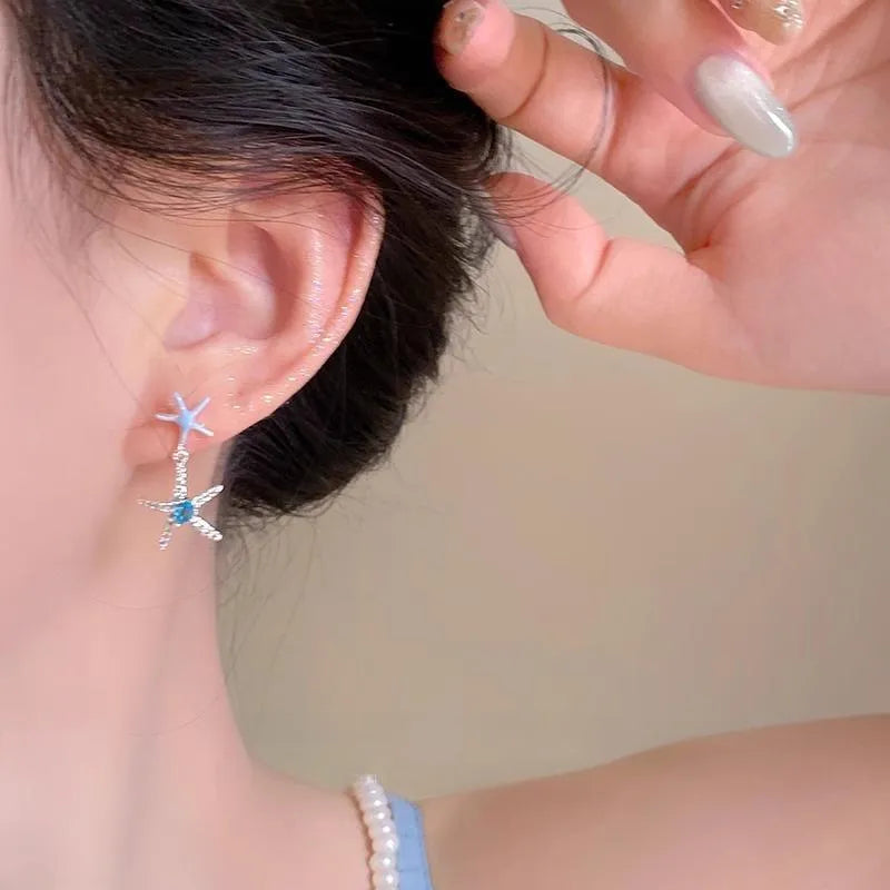 Blue zircon starfish stud earrings in a silver-tone setting with a compact design.