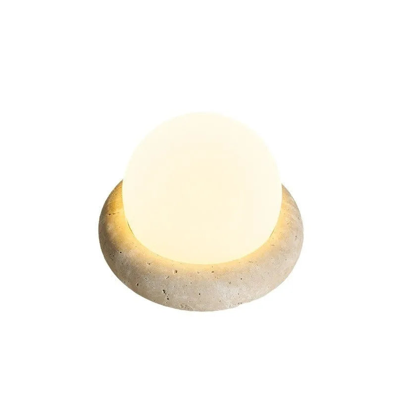 Modern simple bedside night light with remote control on a table.