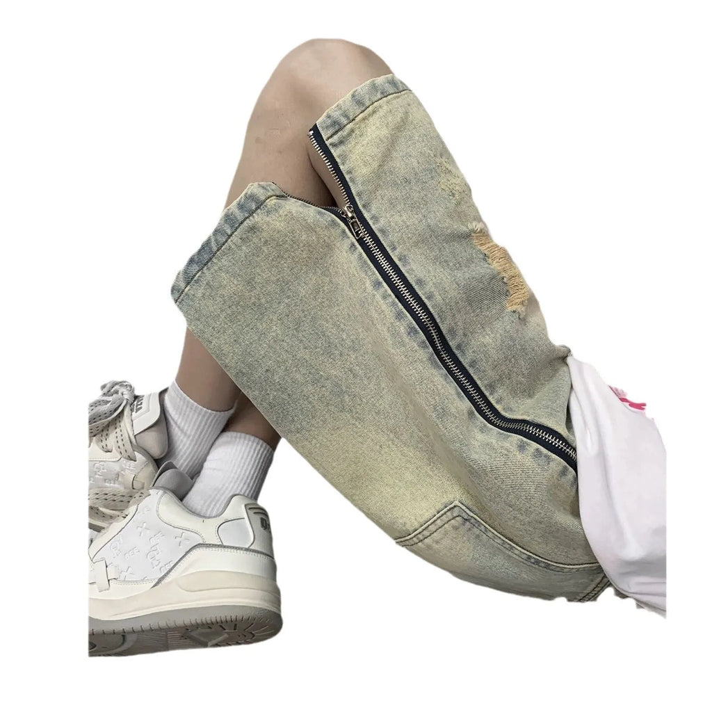 Blue men's loose fit denim shorts with distressed rip details and a yellow mud wash finish.