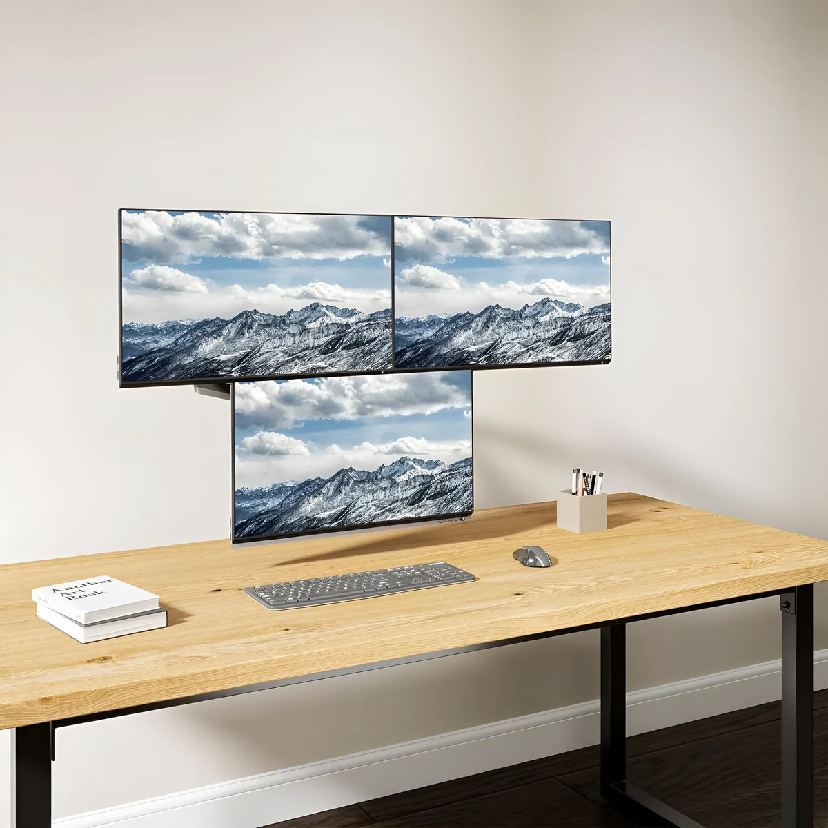 Black three-arm gas spring monitor mounting arm for 13-27 inch screens on a desk.