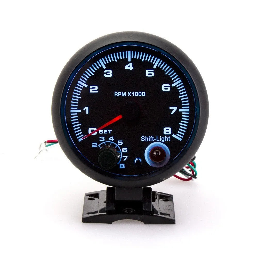 Black universal car tachometer with blue pointer on dial showing 0-8000 RPM range.