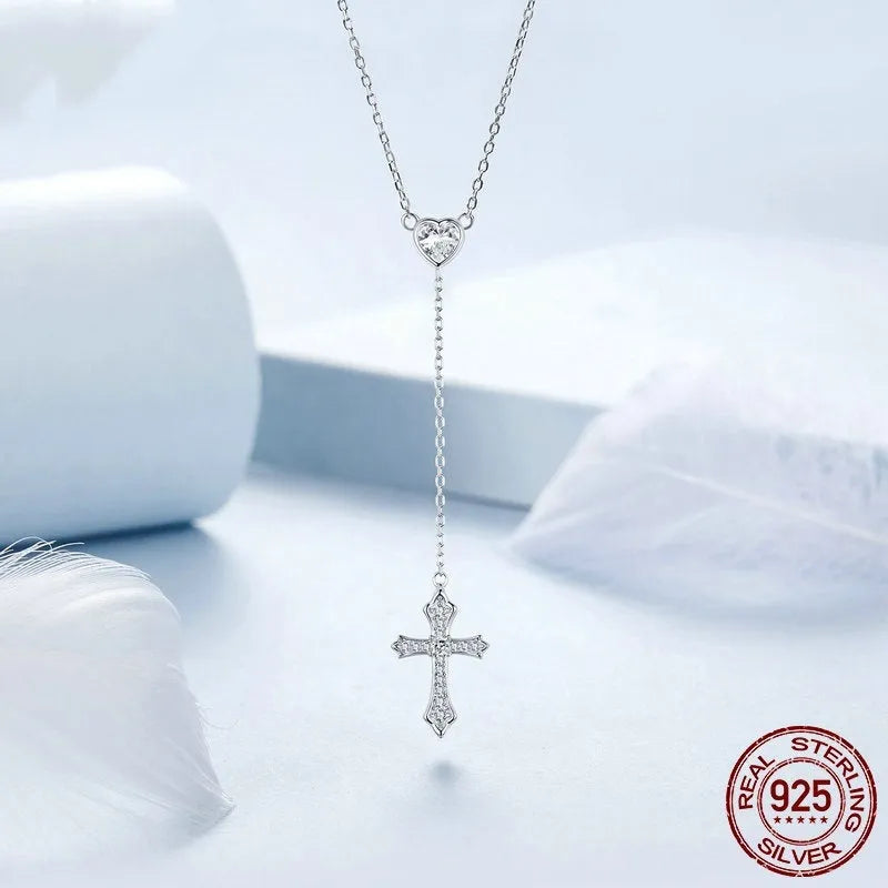 Simple silver love cross necklace on a V-neck O-ring chain for women.