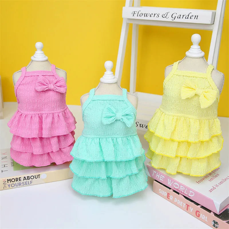 Small dog wearing thin polyester princess dress with layered candy skirt in water green colour