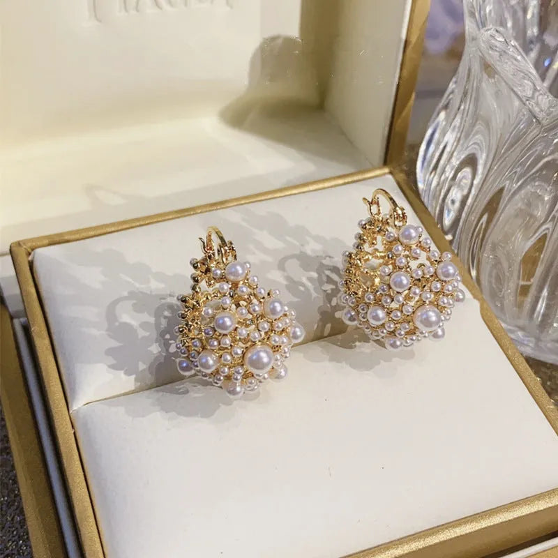 Gold-coloured copper flower basket earrings with small rice-shaped beads and pearl inlay detailing