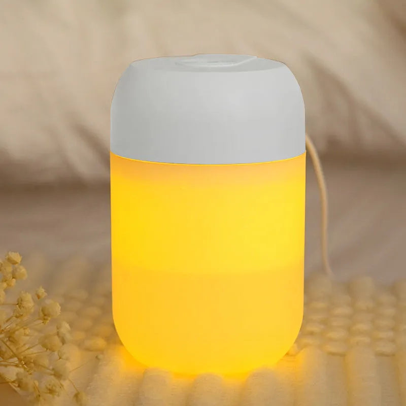 White cylindrical USB-powered mini humidifier with aromatherapy function on a wooden desk.