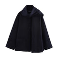 Women's long black coat with a grey artificial fur collar and front pockets.