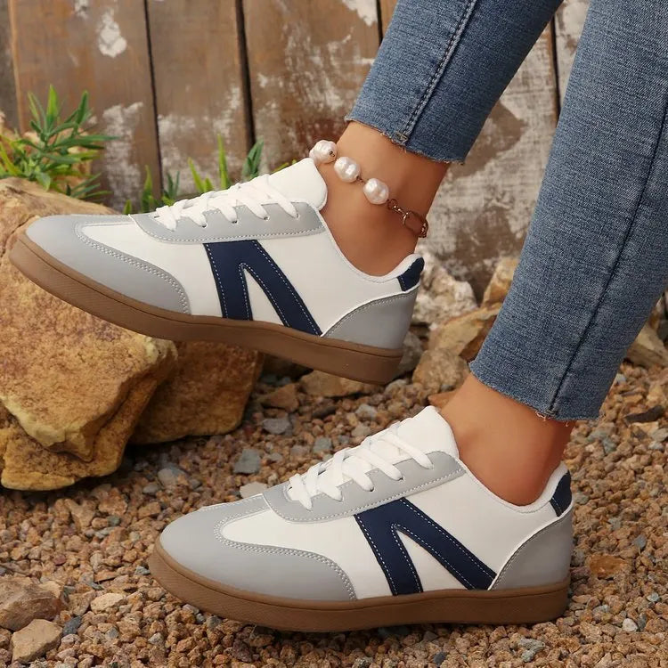 Blue women's low-top hiking shoes with artificial PU upper and rubber sole on a natural background.