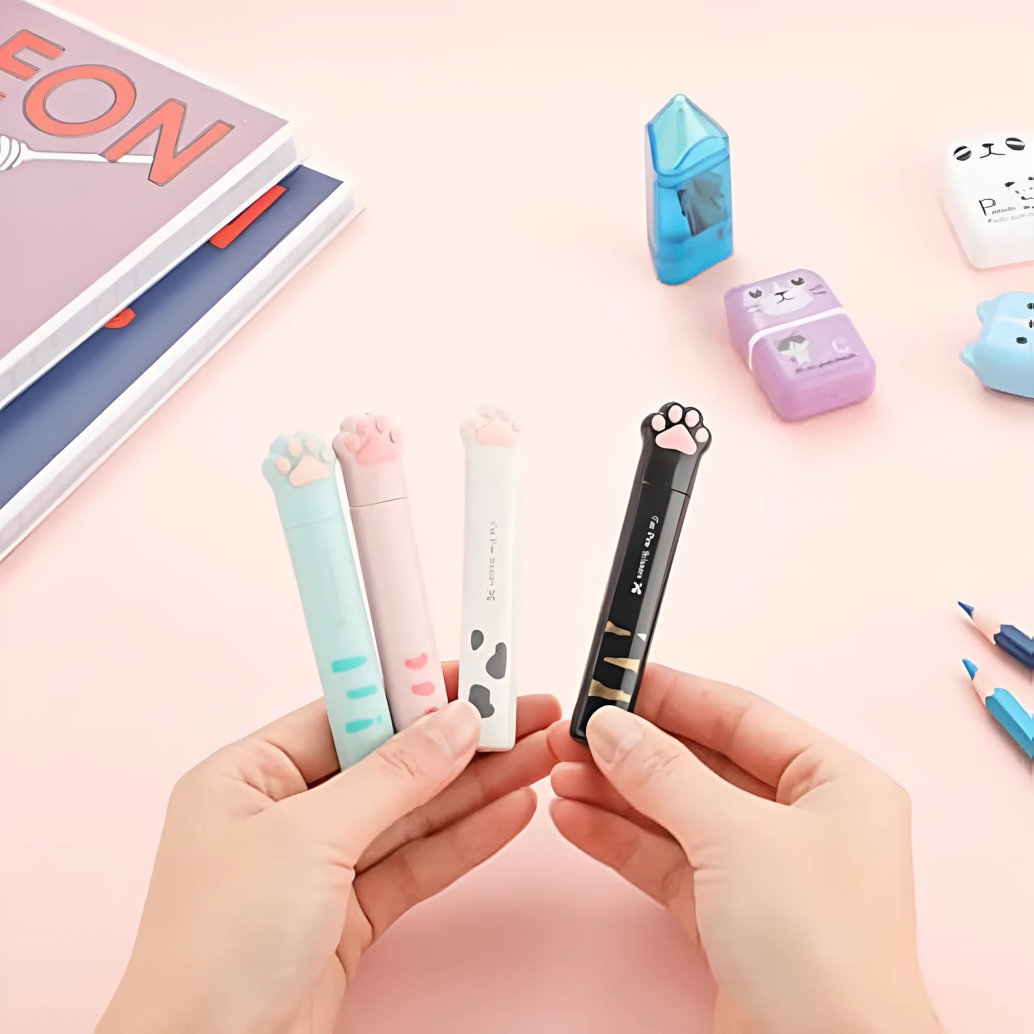 Mini folding scissors with cat paw design on handle, shown in pink, white, black, and blue colour options.