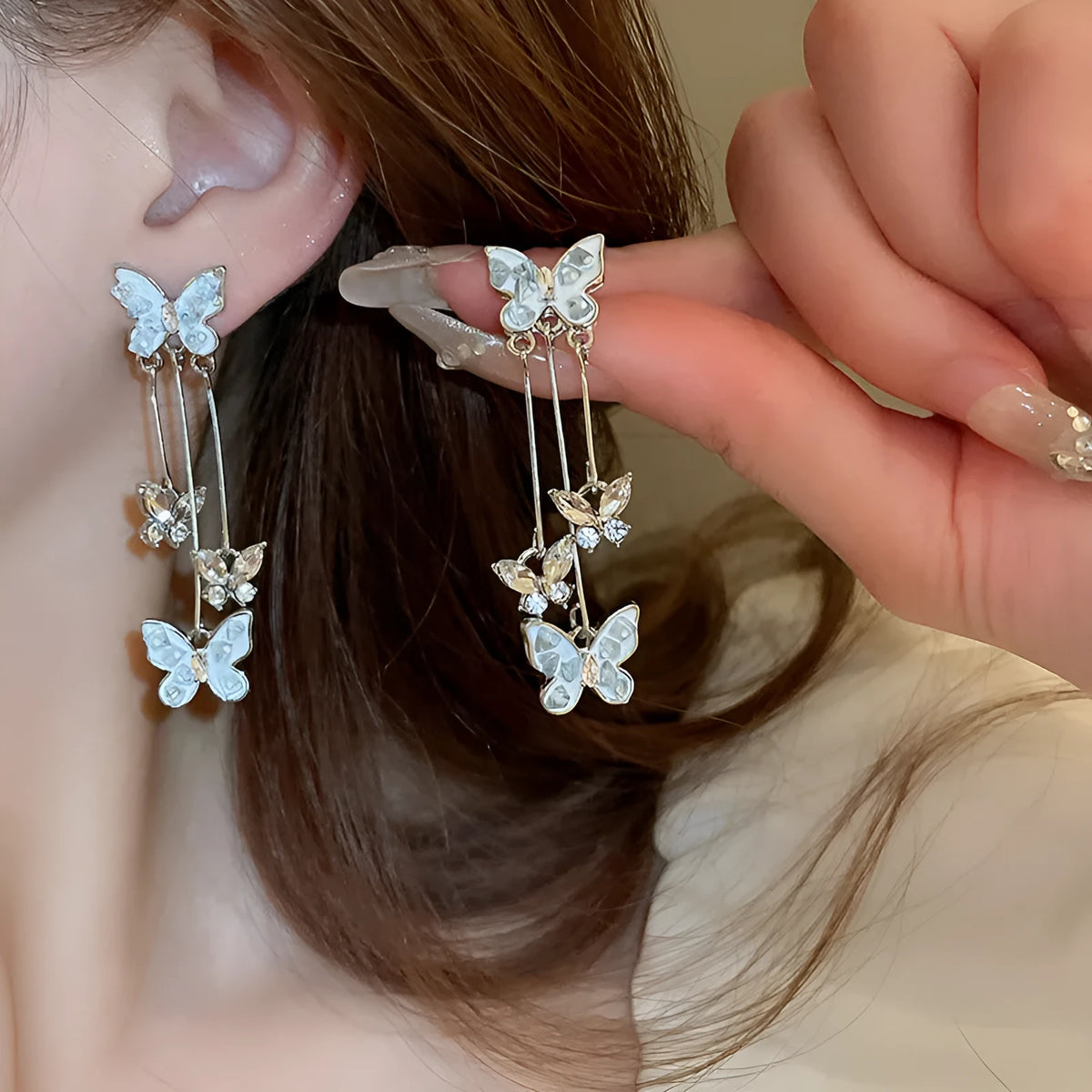 Silver butterfly tassel earrings with blue rhinestone and crystal detail, about 5.7cm long