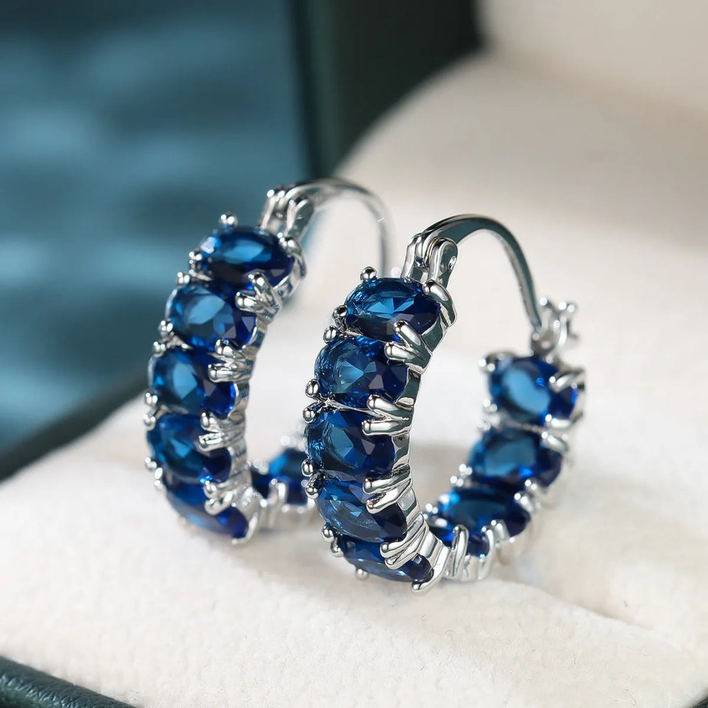 Egg-shaped ear clip earrings for women in electroplated copper, shown in platinum emerald, platinum sapphire blue and gold red
