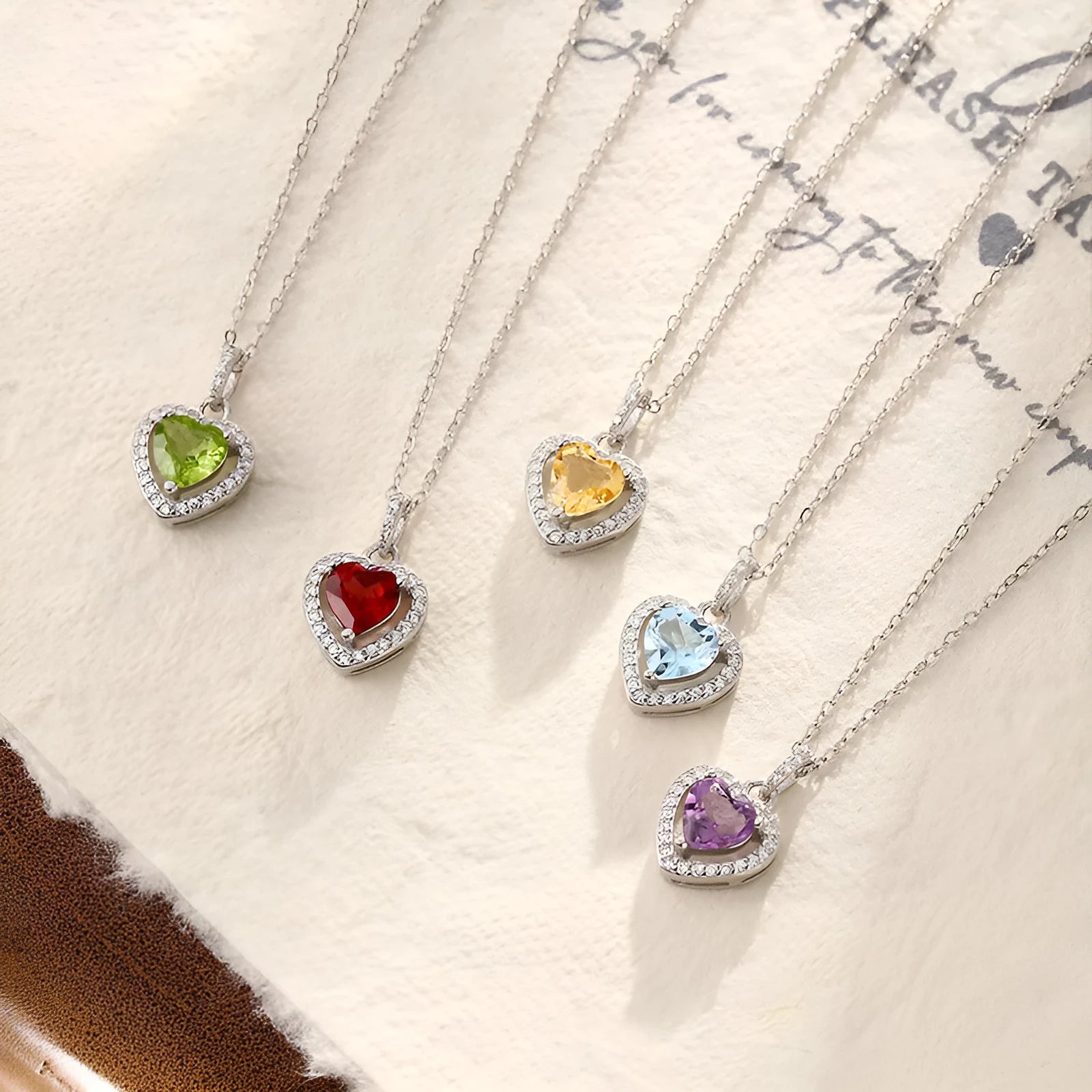 Sterling silver heart pendant necklace with a natural gemstone on an adjustable cross chain.