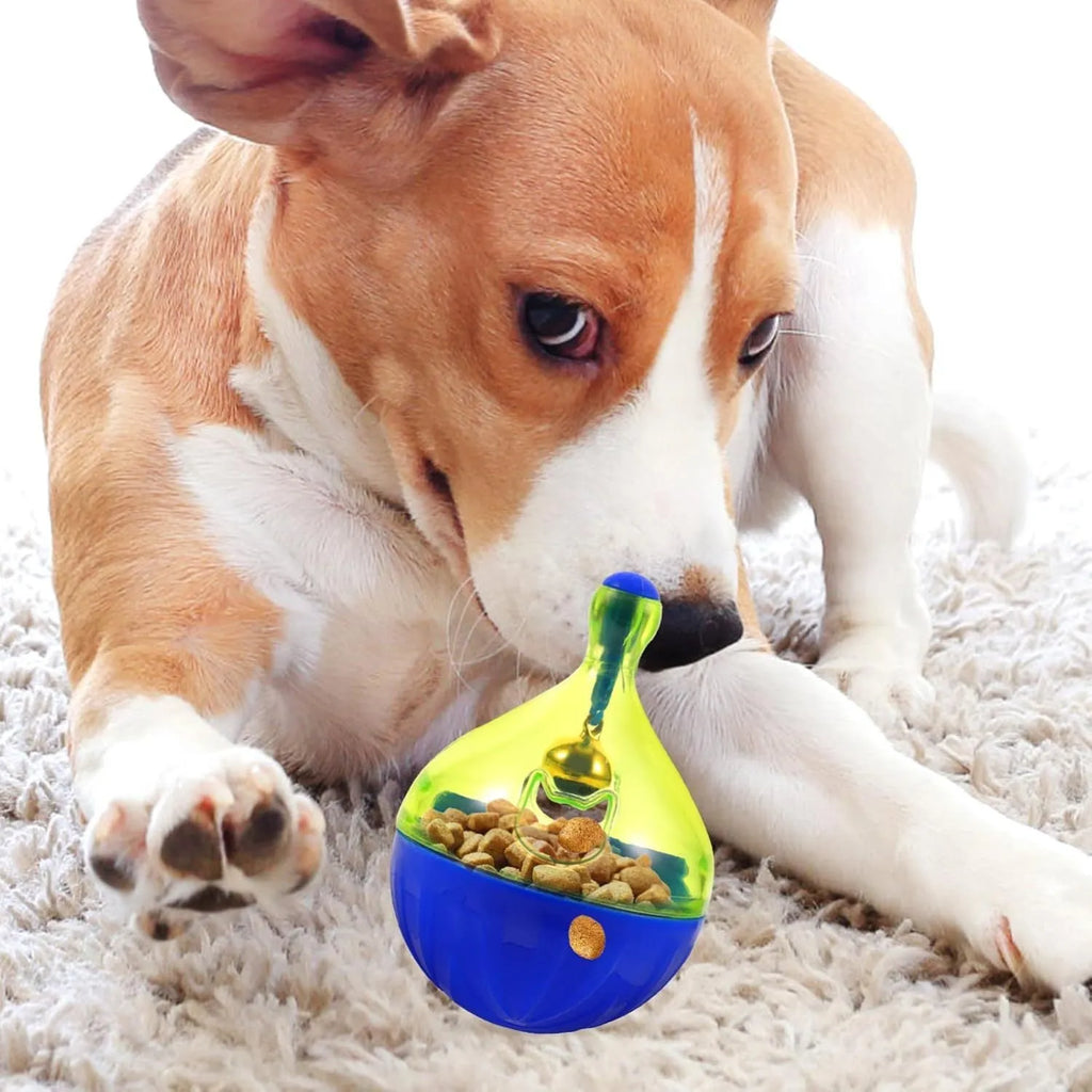 Grey tumbler-shaped interactive pet treat dispenser ball on a wooden floor.