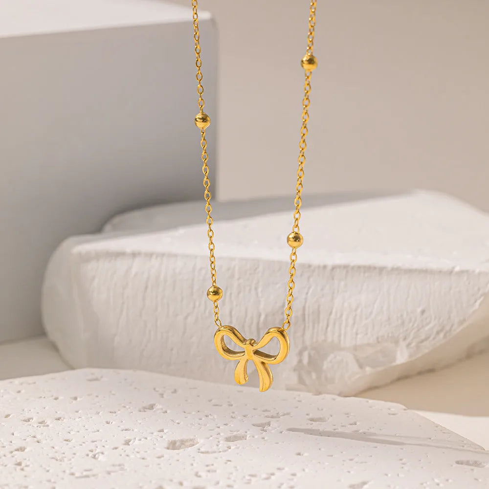 Gold electroplated bow necklace with adjustable cross chain for women