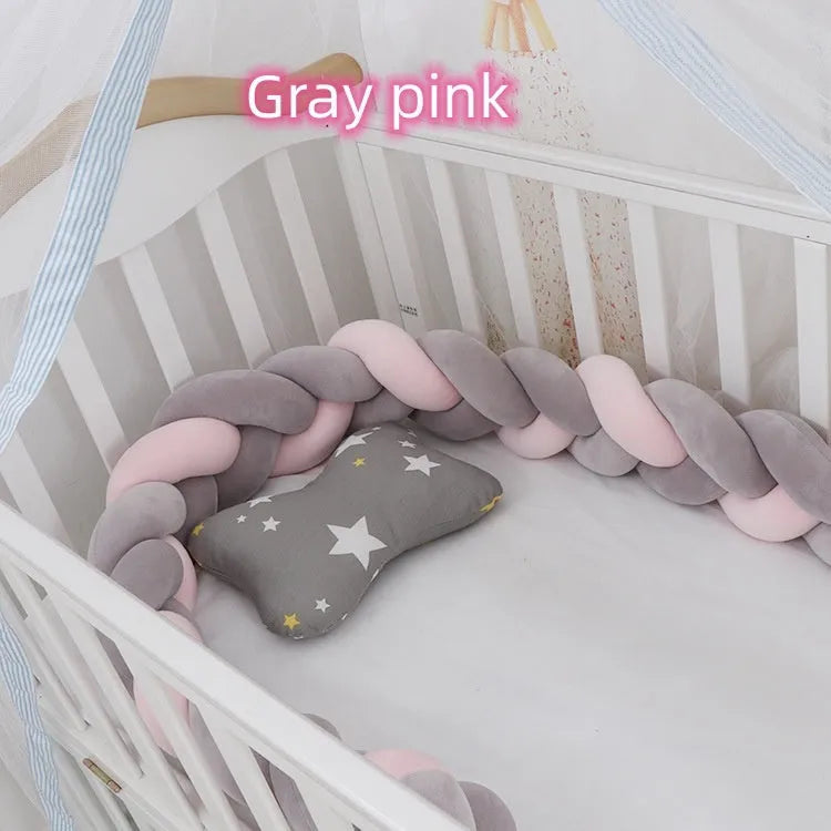 Braided knot design crib bumper in spandex velvet, shown in a light grey colour wrapped around crib slats.