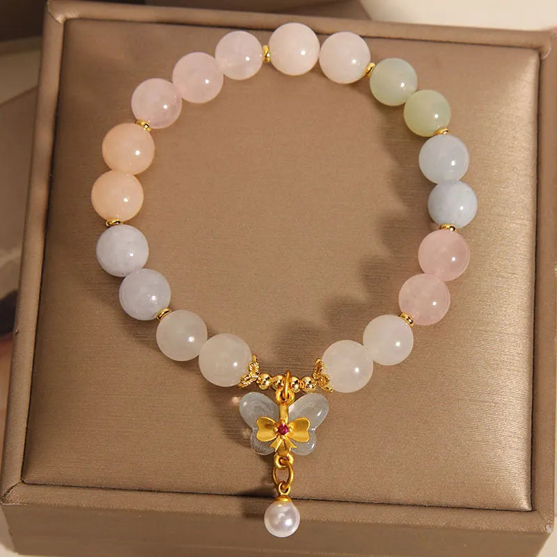 Women's adjustable crystal bracelet with a colourful morganite butterfly pendant on a white background.