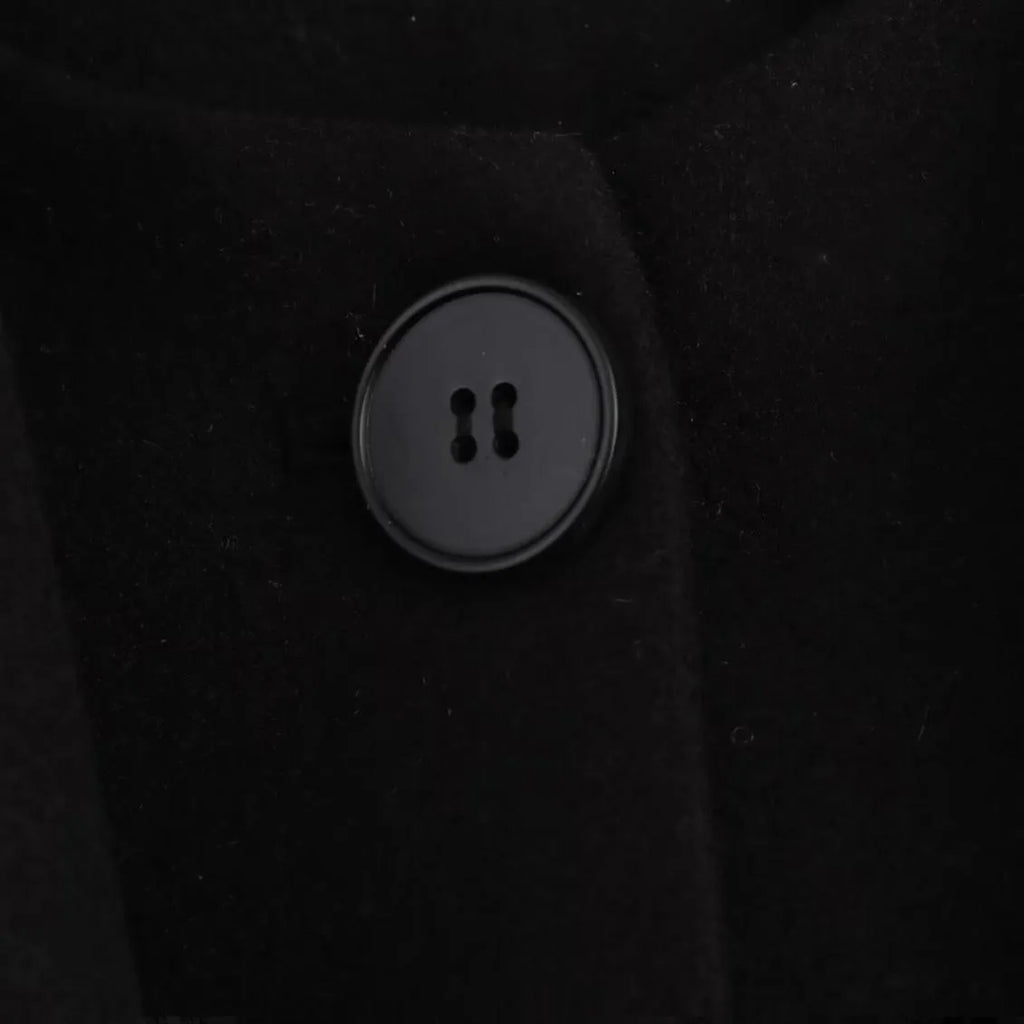 Women's long black coat with a grey artificial fur collar and front pockets.