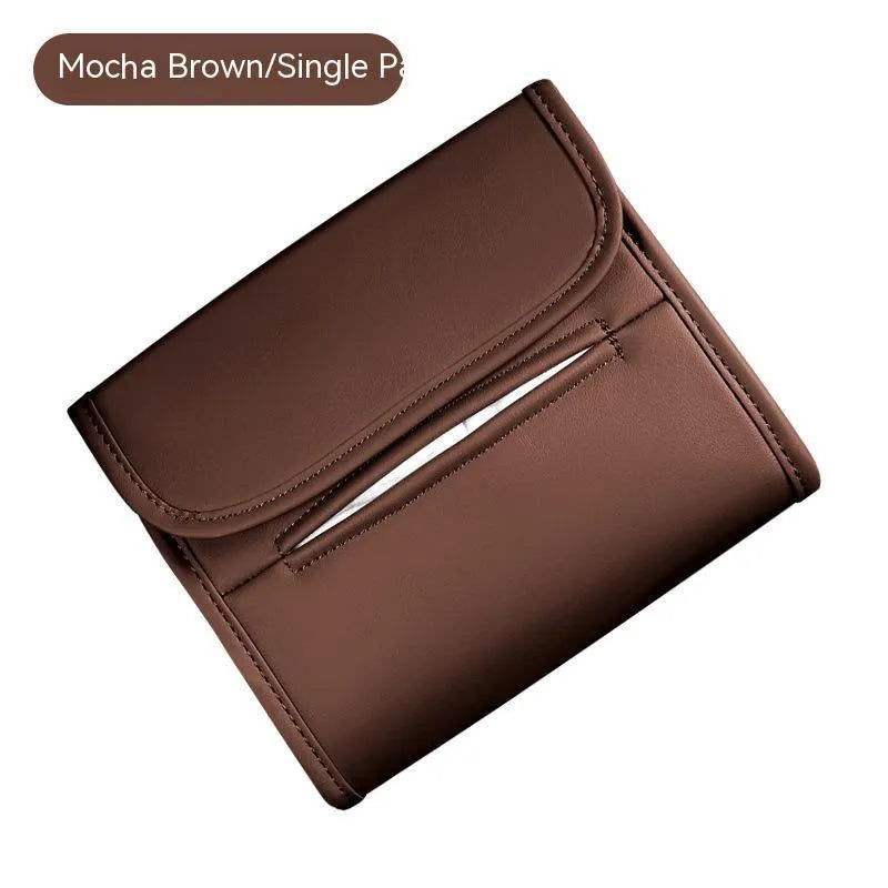 Brown leather car tissue box with elastic strap hanging on a car armrest