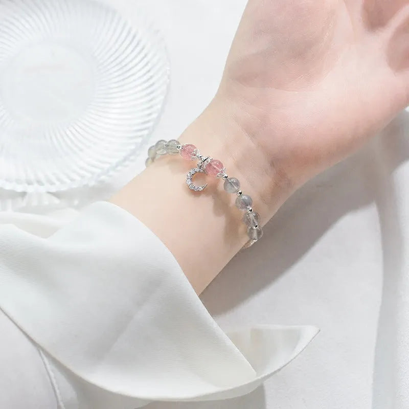 Handmade silver-toned bracelet with a blue-grey 6mm moonstone bead, small crescent moon charm, and clear crystal on an adjustable chain.