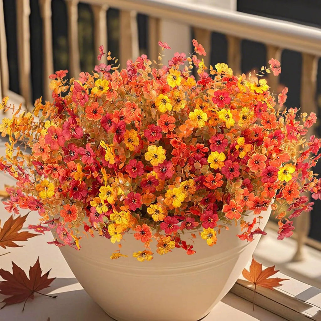 Artificial silk and plastic flower bouquet in autumn colours of red, yellow, and orange for home or wedding decoration