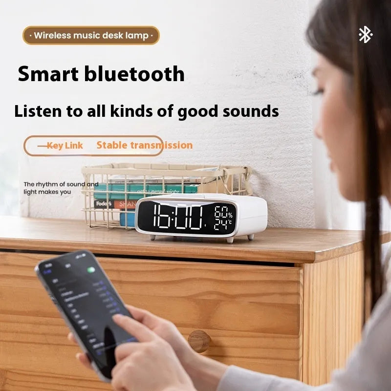 White wireless charging Bluetooth speaker with night light and alarm clock display on desk