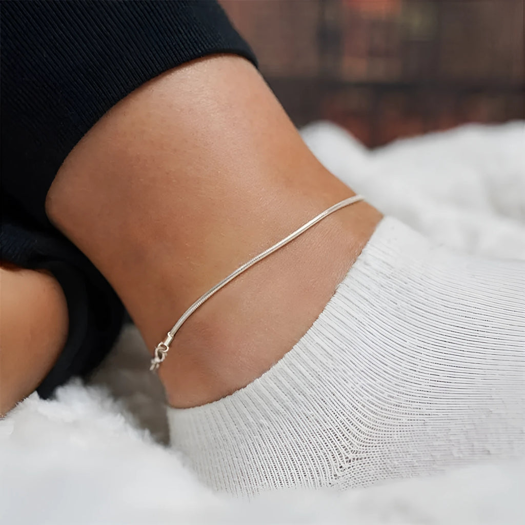 Stainless steel snake chain anklet with adjustable extender in gold colour on a white background