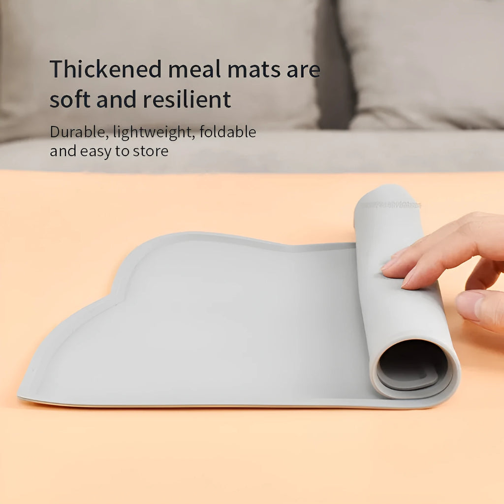 Blue silicone cat head shaped pet feeding mat placed on a wooden floor.