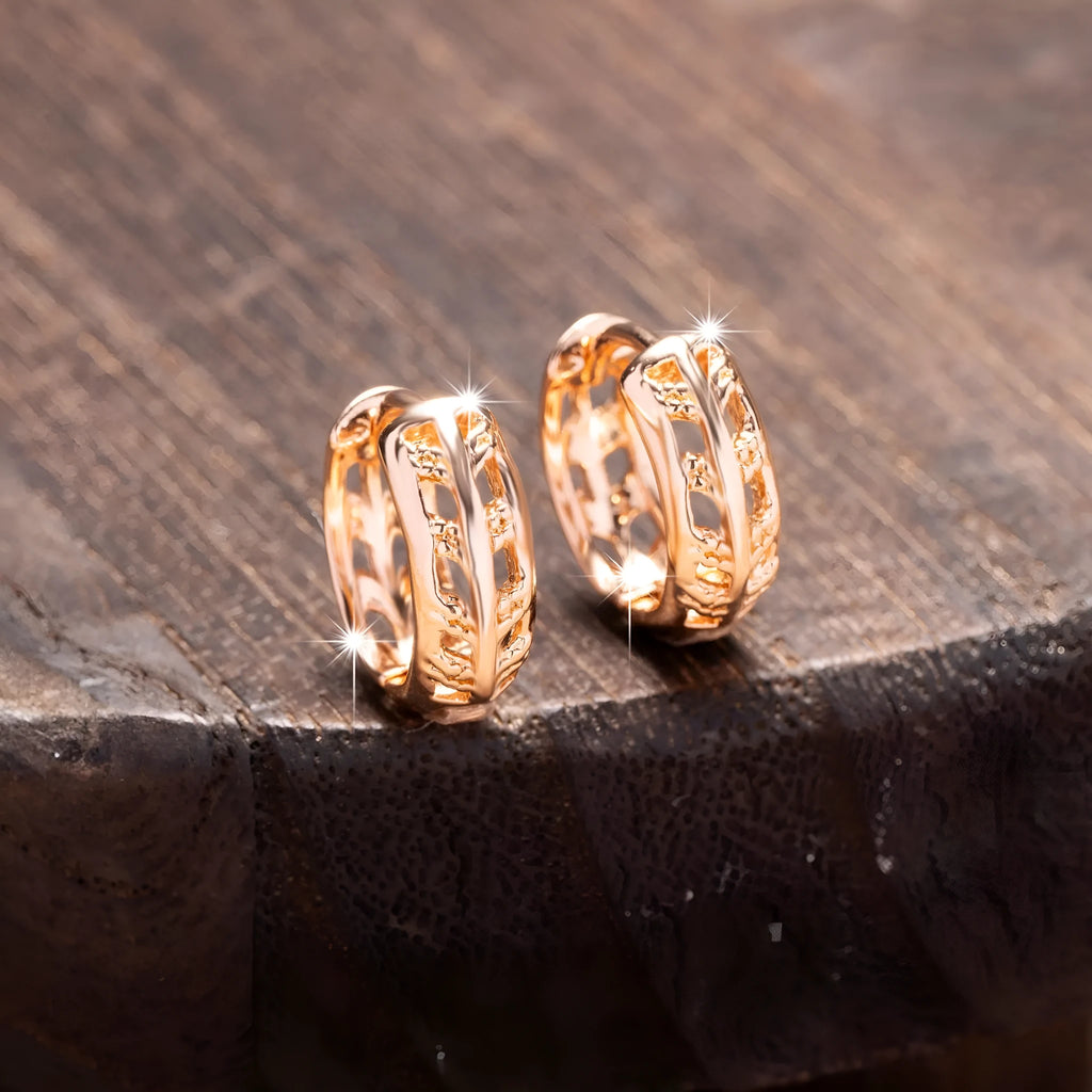 Rose gold coloured hollowed out copper earrings featuring a leaf and heart shape design.