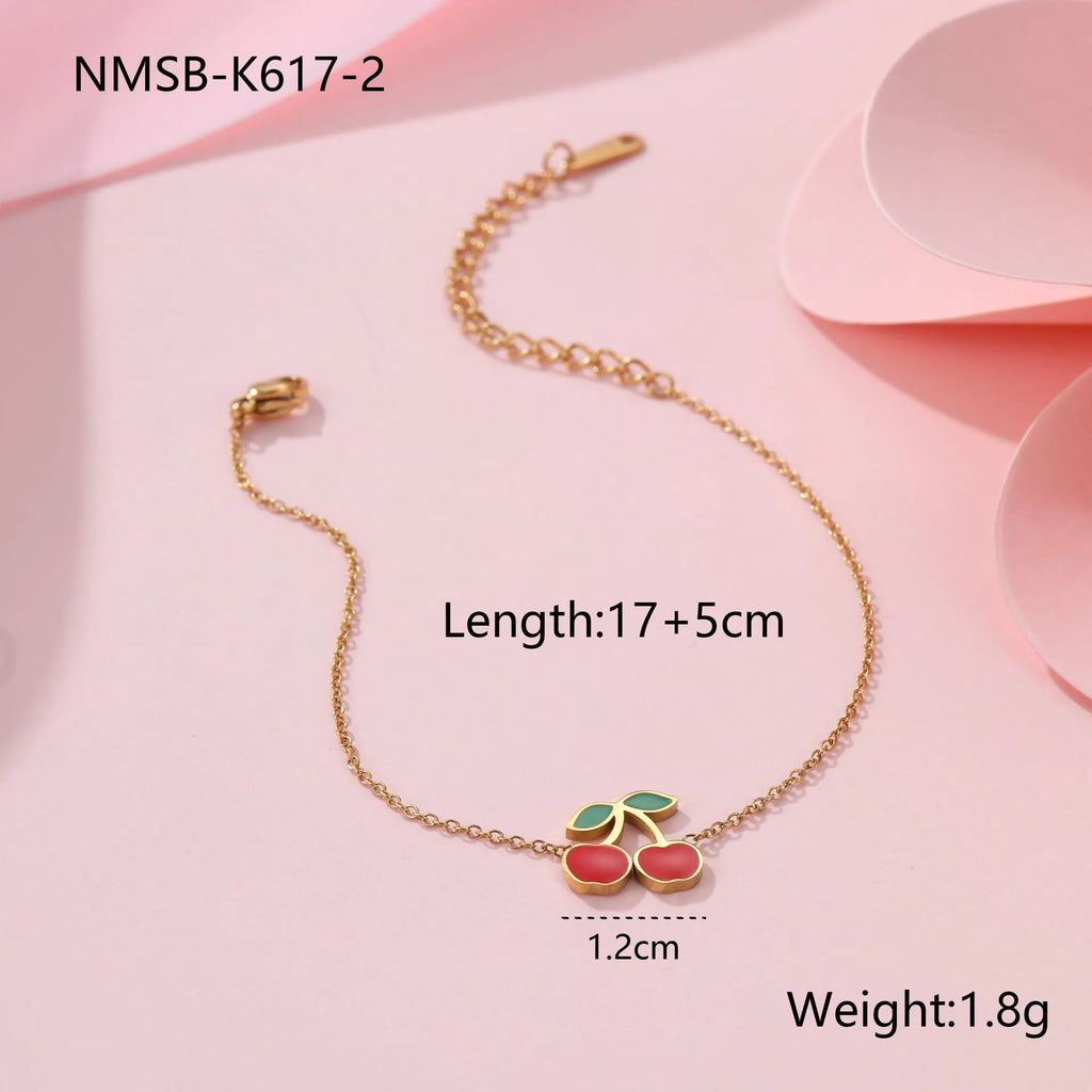 Cherry motif stainless steel jewellery set with gold plating, showing necklace, bracelet, earrings, and ring.