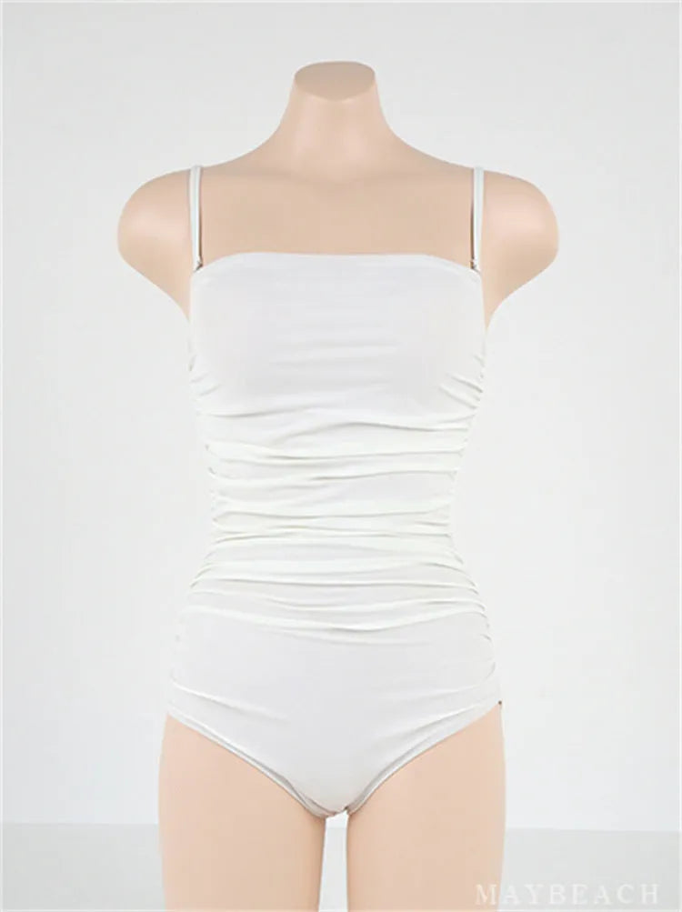 Sling style one-piece swimsuit with belly pleats in slim fit, available in black, blue, white, and yellow.