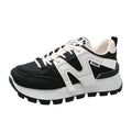 Low top unisex running sneaker in black or white with round toe and flat rubber sole.