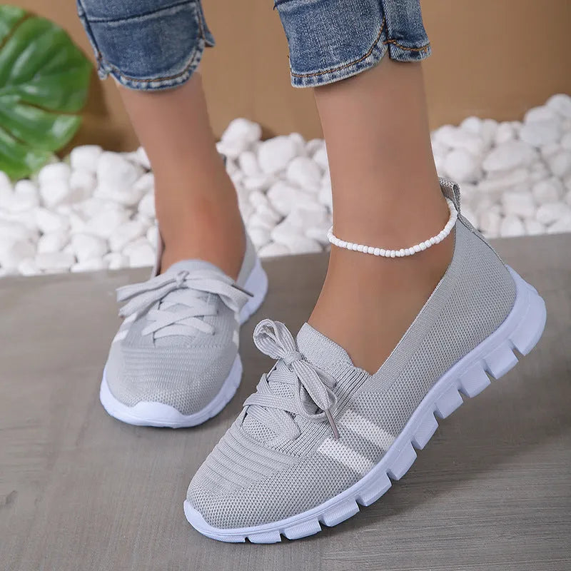 Women's lace-up mesh trainers with flat rubber sole, round toe and shallow mouth, shown in grey, black, orange and brown