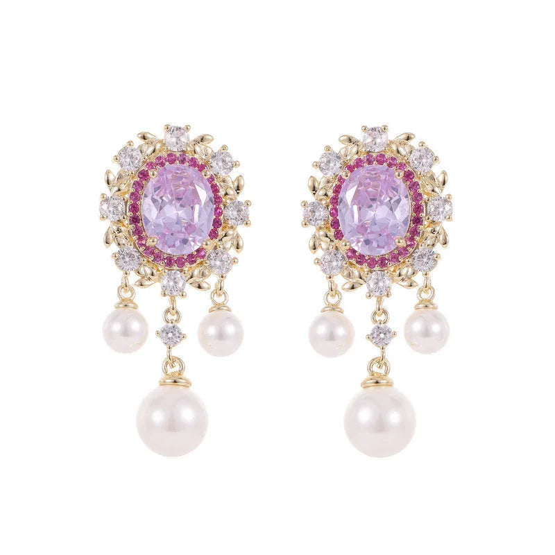 A pair of oval-shaped geometric drop earrings with a pearl tassel and zircon inlay on copper, shown in light purple.