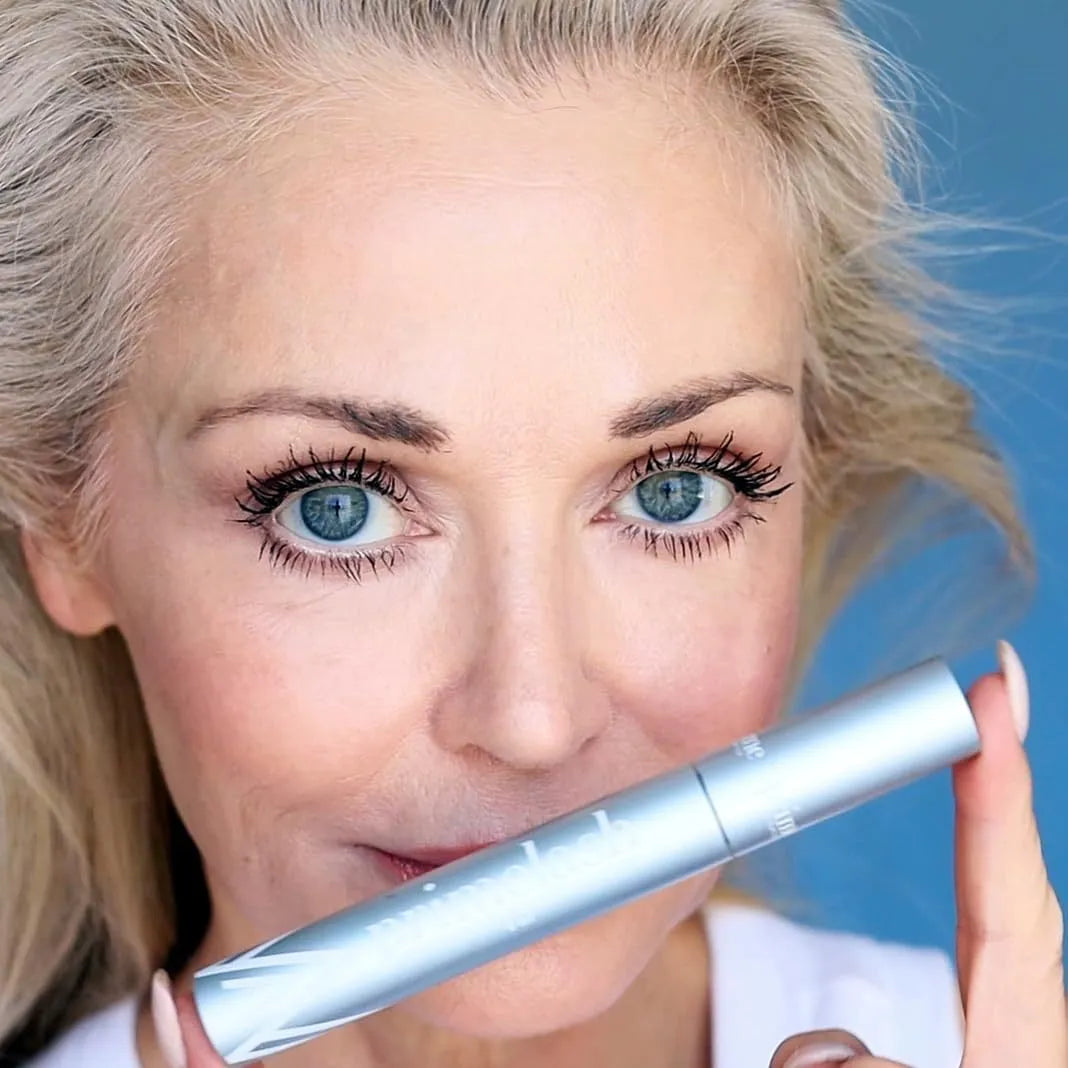 A single black plastic eyelash comb with fine bristles for mascara application.