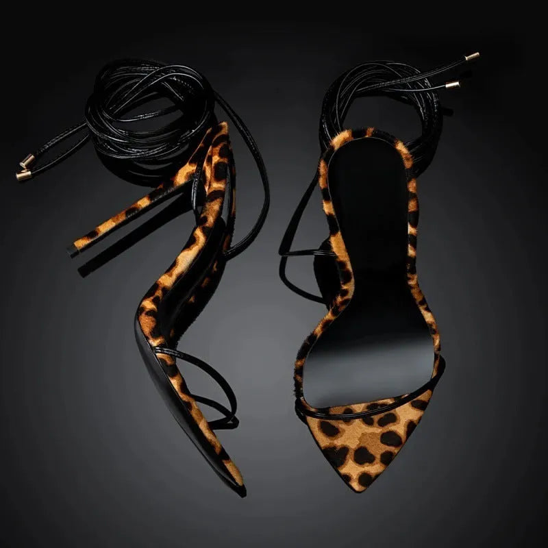 Women's leopard print Roman sandals with pointed toe and lace-up buckle design.