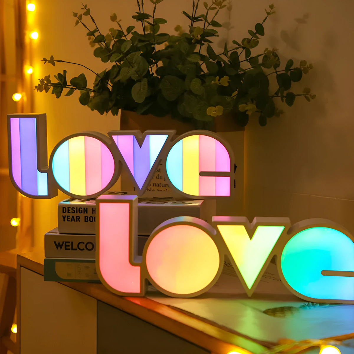 LED LOVE light with rainbow shade measuring 35.5cm, glowing softly on a wooden desk for Valentine's decoration.