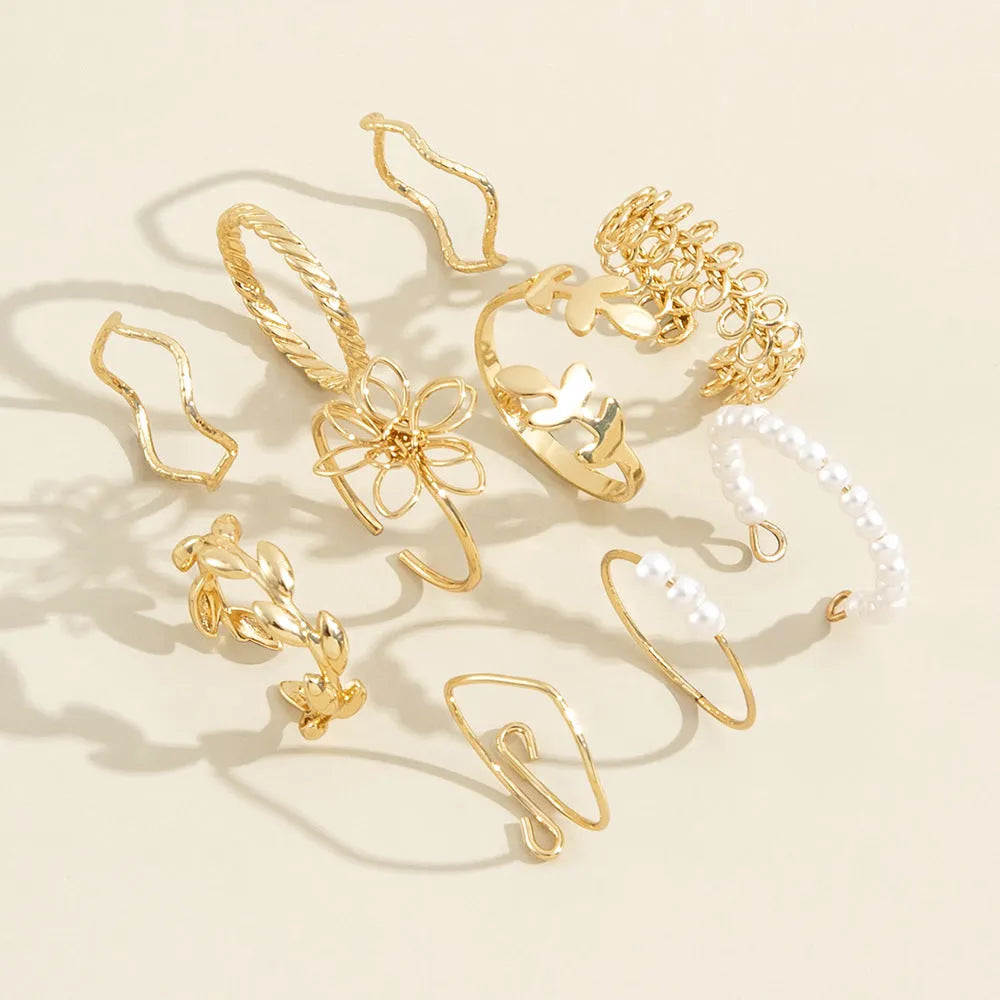 Gold coloured openwork flower design ring for women on a white background.