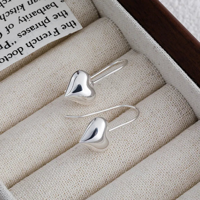 Silver heart-shaped earrings with glossy finish and three-dimensional Korean-style design